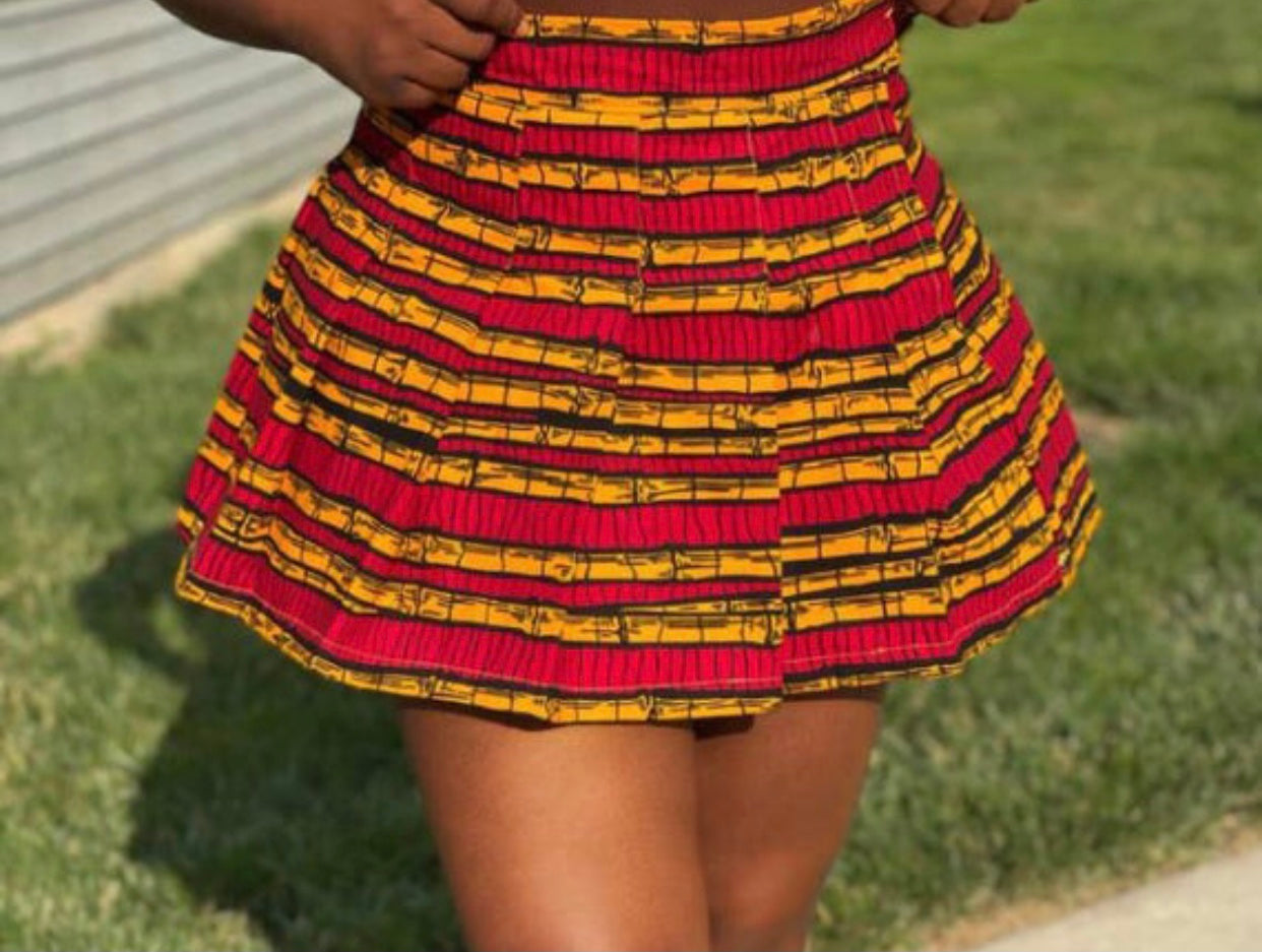 Sexy tennis/sporty pleated mini skirt made from a red, yellow and black sugarcane designed ankara fabric.
