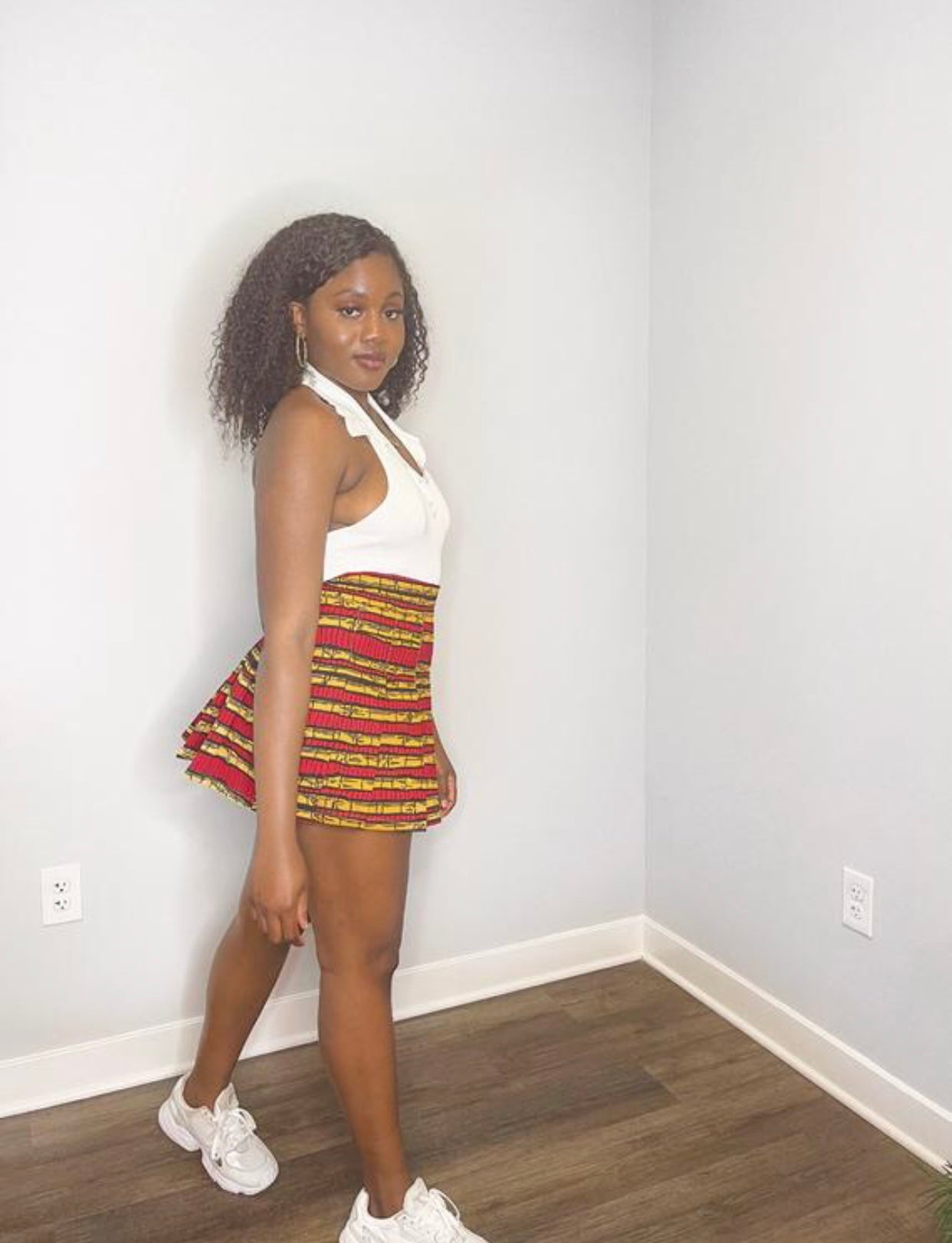 Sexy tennis/sporty pleated mini skirt made from a red, yellow and black sugarcane designed ankara fabric.