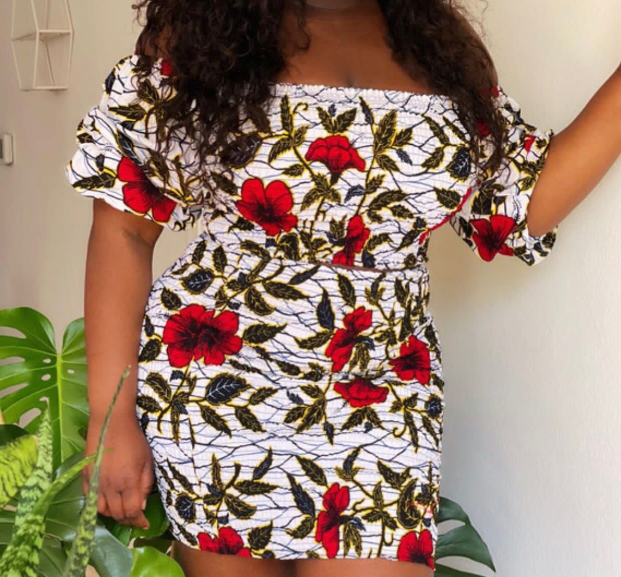 A stretchy two piece short skirt and a quarter sleeve puff hand top made with Ankara wax print/fabric designed with white, black gold and red beautiful 🌹colours and pattern