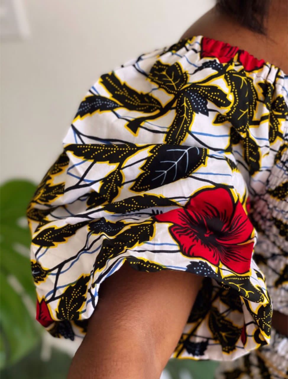 A stretchy two piece short skirt and a quarter sleeve puff hand top made with Ankara wax print/fabric designed with white, black gold and red beautiful 🌹colours and pattern