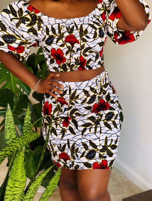 A stretchy two piece short skirt and a quarter sleeve puff hand top made with Ankara wax print/fabric designed with white, black gold and red beautiful 🌹colours and pattern