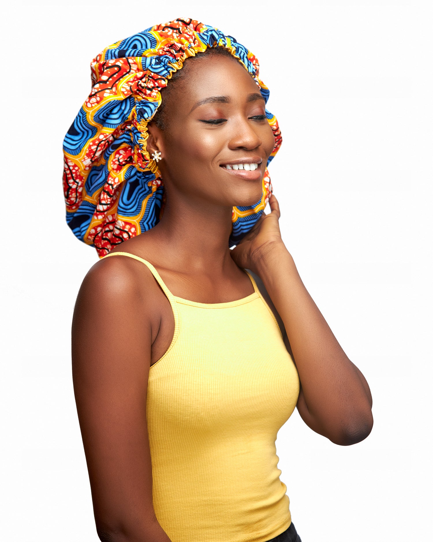 An Ankara Wax Print Made of Orange,White, Yellow, Seablue And Black Blend of Beautiful Colours And Pattern, Hand Made Elastic With Yellow Silk lined Hair Bonnet